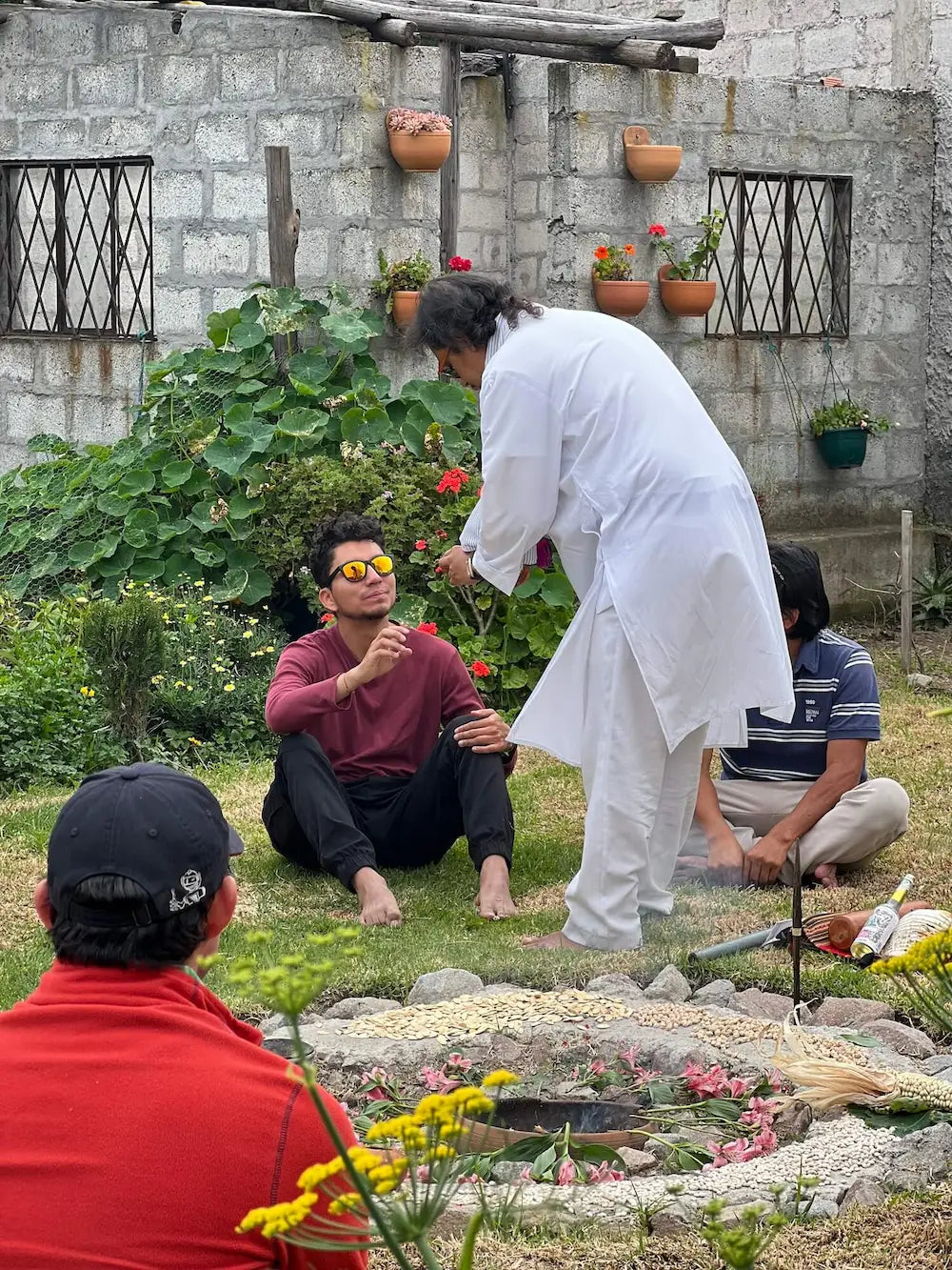 Spiritual guide offering cacao during an ancestral ceremony surrounded by symbolic elements and community members