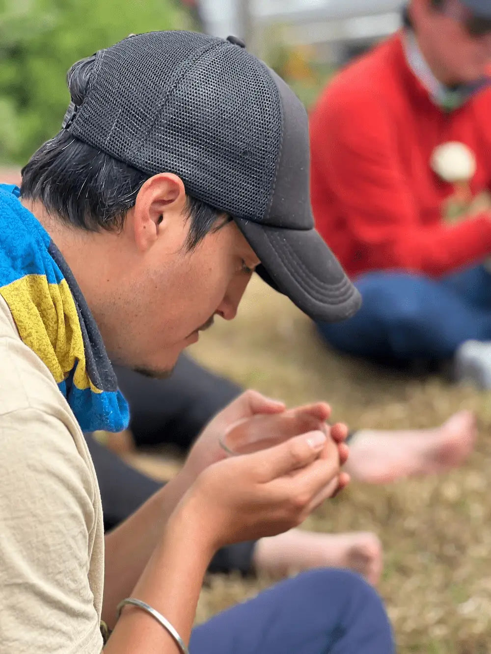 Man holding a bowl of ceremonial cacao with eyes closed, engaging in a moment of reflection and intention during a spiritual gathering