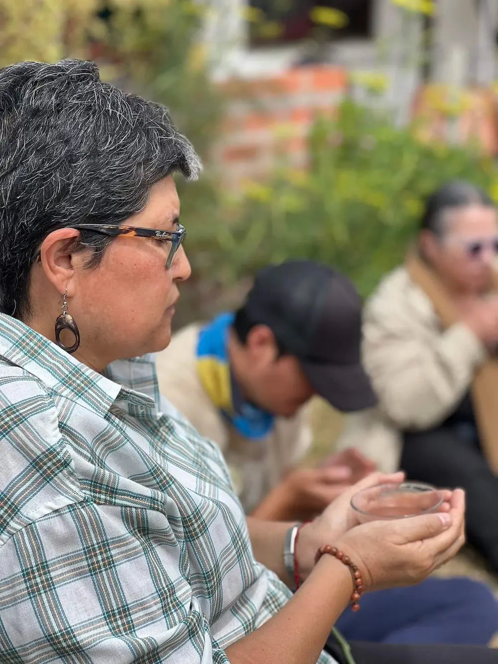 Woman holding a bowl of ceremonial cacao in a moment of quiet prayer and connection during a community ritual