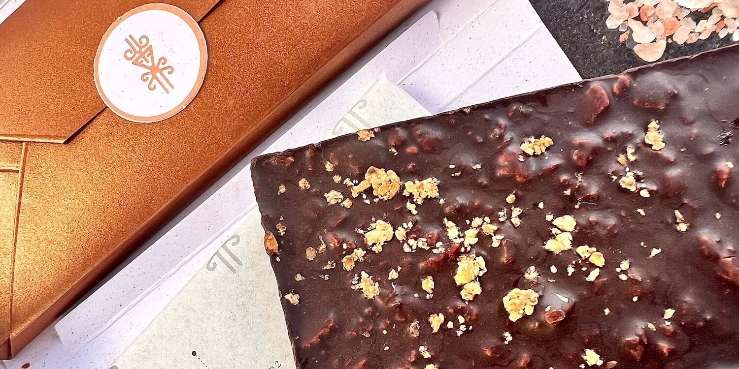 Close-up of Cognitive Collection dark chocolate bar topped with golden granola pieces.