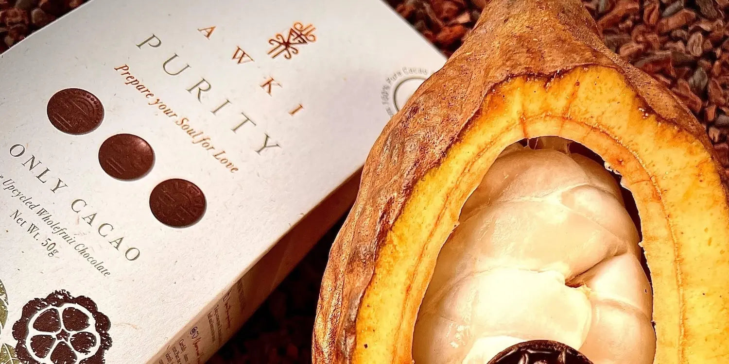 Purity Collection chocolate bar next to a freshly cut cacao pod showcasing white cacao pulp.