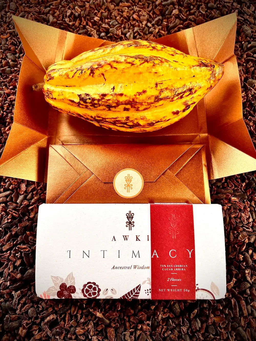 Unboxed Awki Intimacy chocolate bar with sparkling toppings and premium gold envelope packaging on dark wood surface
