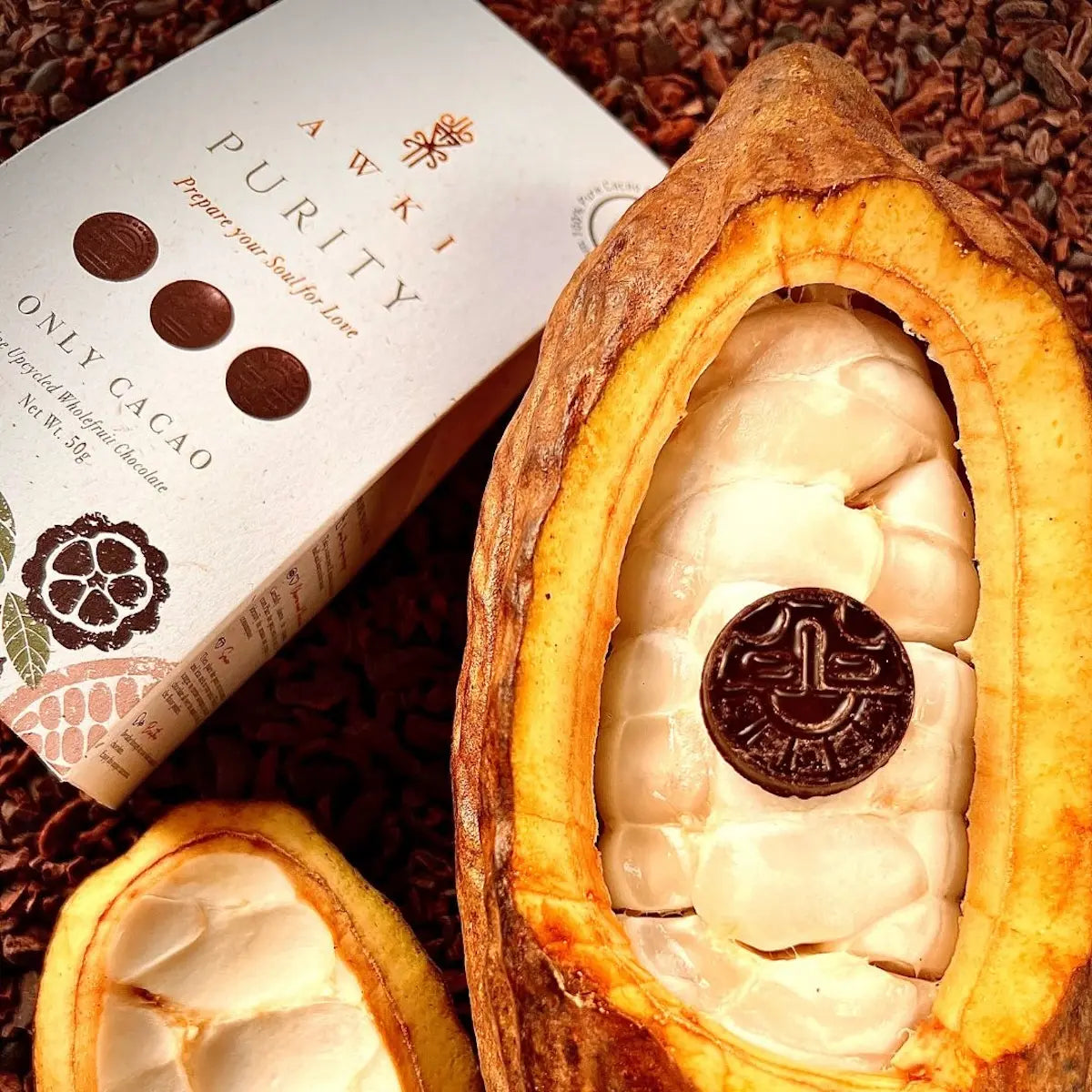 Awki Purity chocolate coin placed inside a fresh open cacao fruit surrounded by nibs.